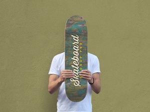 Homme tenant une maquette de skateboard