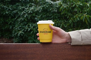 Free Hand Holding Coffee Cup Mockup 